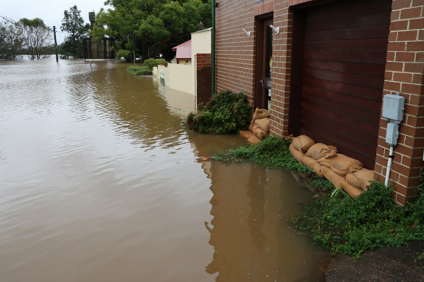 Flood water surrounding a brick property after a major water event